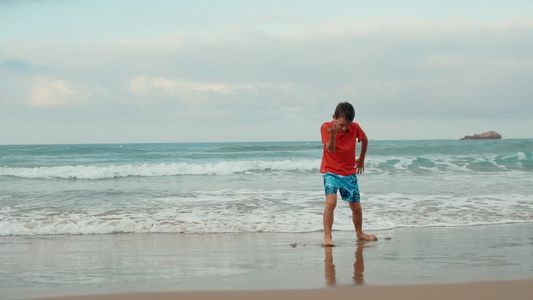快乐的男孩在沙滩上跳舞度假视频