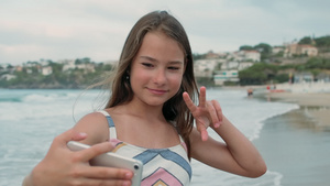 快乐的女孩在海边度过时光拿手机自拍16秒视频