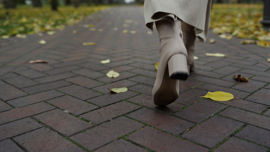 在秋天公园穿靴子走在路上视频