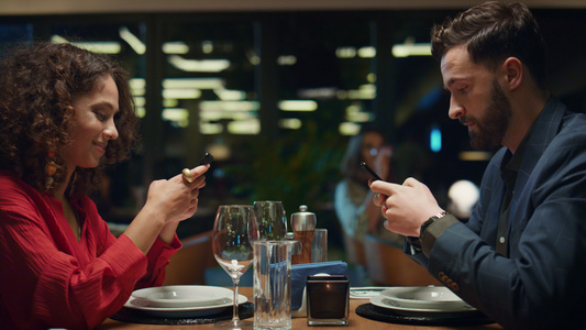 多民族夫妇在高档餐厅发短信手机视频