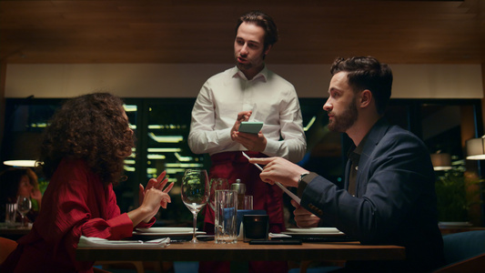 微笑的服务员在餐厅约会时为情侣服务视频