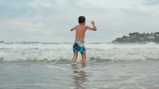 快乐的男孩在海岸线玩得开心视频