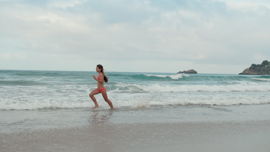 快乐的女孩在沙滩上奔跑视频