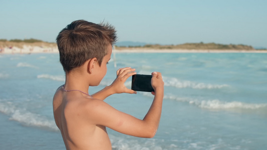 小那还在海边拿着手机拍照视频