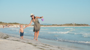 快乐的宝宝和妈妈在沙滩边快乐休闲22秒视频