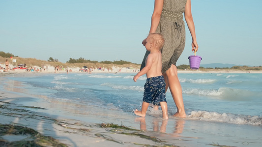 母亲牵着小宝宝的手走在沙滩上视频