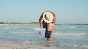 年轻妈妈在海边沙滩牵着宝宝23秒视频