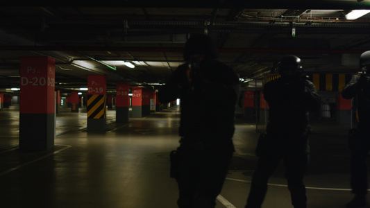 武装的特警特警队察在黑暗中检查地下停车区视频