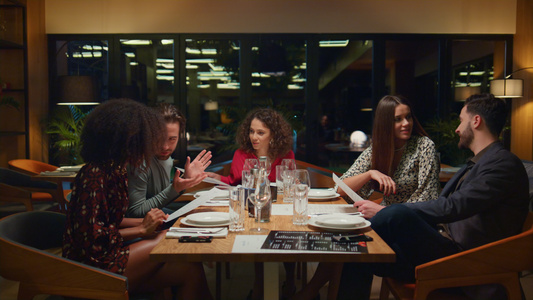不同的团体在晚上坐在餐厅的桌子上视频