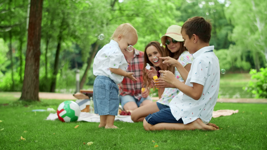 父母和孩子一起在户外野餐休闲娱乐视频