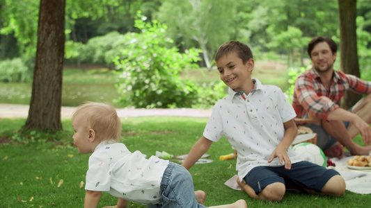 可爱的宝宝与哥哥玩游戏父母和孩子在户外野餐休闲视频