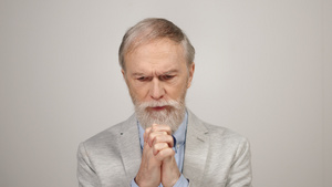 精神紧张的白胡子老年男性在室内祈祷17秒视频