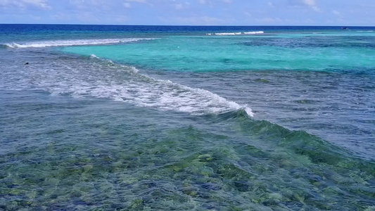 蓝色环礁湖和阳光下清洁沙滩背景的阳光明媚的沿海海滩视频