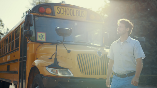 年轻的校车司机独自站在学术班车附近视频