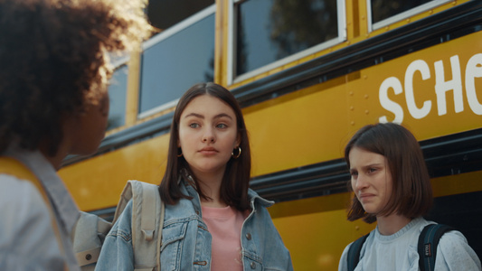 站在黄色公共汽车上的三个女学生视频