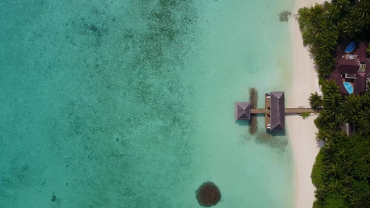 蓝色环礁湖和靠近珊瑚礁的白色沙滩背景所呈现的完美海岸视频