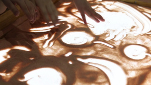 一群孩子在玻璃上用沙子画画学习用沙子在玻璃上画画6秒视频