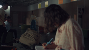 十几岁的女孩在速写本上写下笔记坐在学校的走廊里30秒视频