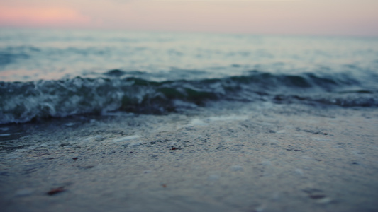 蓝色的海浪在寒冷的早晨日出时溅起沙滩视频
