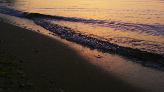 特写海浪在寒冷的傍晚日落黄昏慢动作中溅起沙滩视频