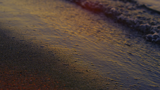 特写平静的海浪在黄昏时分反射明亮的金色日落视频