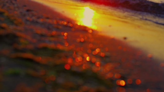 日落傍晚海浪中的太阳光反射溅起金色的沙滩视频