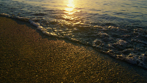 金色日出时海浪溅起沙滩沙子的太阳光反射19秒视频