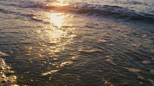 在阳光明媚的早晨平静的海浪溅起沙滩上的沙子视频