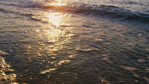 在阳光明媚的早晨平静的海浪溅起沙滩上的沙子16秒视频