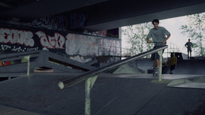 千禧一代男子在城市滑板公园骑着滑板车跳上铁轨18秒视频