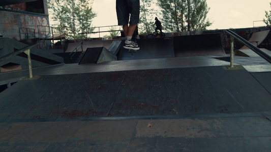 极端男孩在城市滑板公园的坡道上骑着滑板车跳跃视频