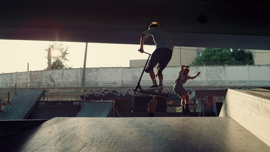 青少年运动员在城市明亮的阳光滑板公园一起表演特技视频