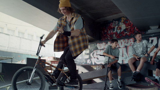 活跃的人在墙上涂鸦的滑板公园练习越野自行车视频