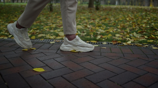 在城市公园里行走的男性脚步特写视频