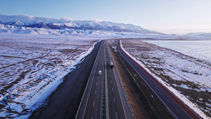 航拍雪地公路上行驶的汽车20秒视频