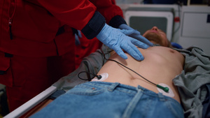 急救车在担架上用急救车对受伤男子进行心肺复苏手术的辅助医务人员手26秒视频