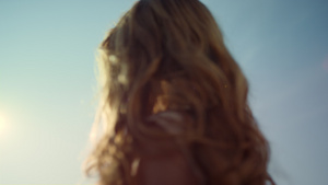 美丽的头发站在阳光下的年轻女子15秒视频