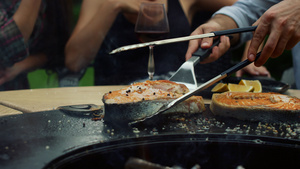 男厨师在外面的bbq烤架上把鱼片切开28秒视频