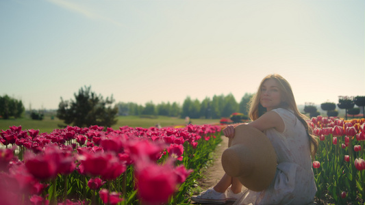 顽皮的女孩在夕阳下的花丛中视频