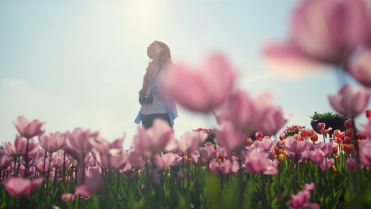 穿着休闲服的年轻女子站在阳光下花园里的梦中视频