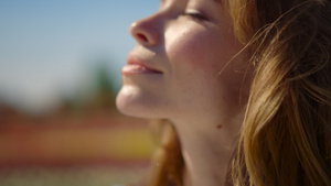 漂亮的红头发女孩闭着眼睛在夏日外面微笑着做梦8秒视频