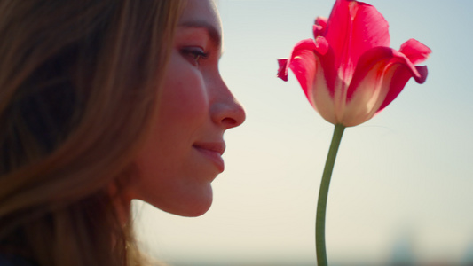 特写美丽的女人脸享受郁金香花在柔和的日落光线室外视频