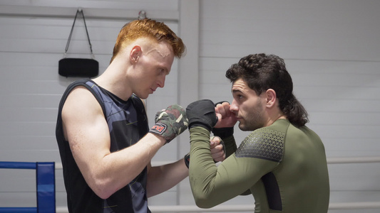 两名身着拳击绷带的拳击手站在拳击台上的准备姿势跆拳道视频