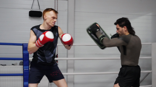 拳击手在与教练进行个人训练时用拳击垫训练拳拳击手套视频