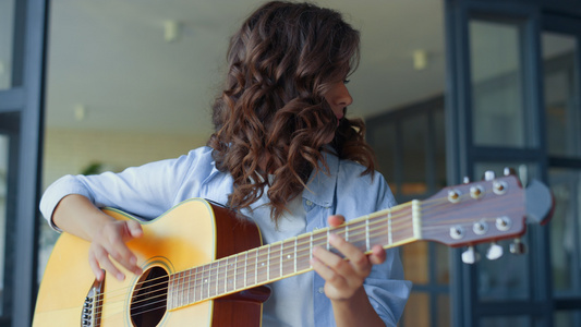 女孩在吉他上练习音乐 深思的吉他手在上创作音乐视频
