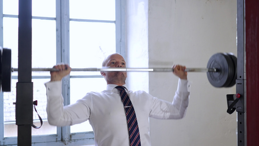 商人在健身房里用杠铃锻炼努力工作的经营理念有哑铃的视频