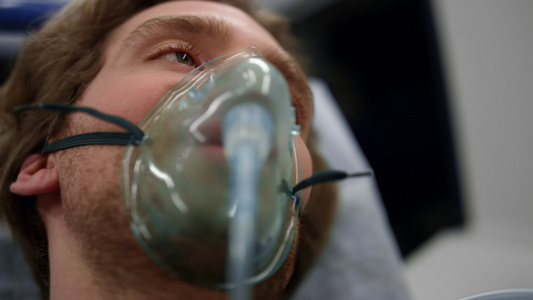 身戴氧气面具的受伤男子躺在救护车上的担架视频