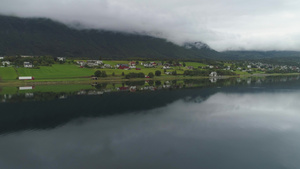 小小镇和湖面反射云雾多的夏季日诺威绿色风景空中观察21秒视频