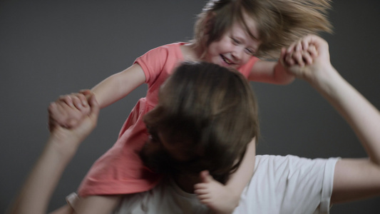 骑在爸爸身上年轻的父亲把他的女儿扔在爸爸背上父亲节视频