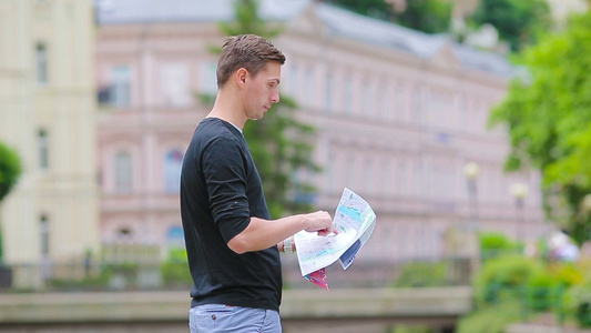 Caucasian男孩看着欧洲城市的地图寻找目的地视频